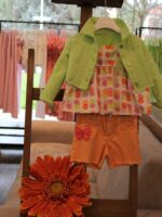 Giubbotto jeans bimba Giubbotto jeans bimba con colletto camicia, allacciatura a bottoni, fondo sfrangiato, motivo strass applicati sul davanti.