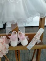 Abito Dalia Mimilù Abito da cerimonia e Battesimo color latte, modello senza maniche in misto cotone con gonna in tulle multistrato e ampia sottogonna, elegante corpino ricamato, cintura in organza color rosa tenue -annodabile sul retro con un grande fiocco e ampi lembi - completata da una raffinata spilla floreale rosa polvere con dettagli in pizzo. Abito da Battesimo Abito da Cerimonia Neonata