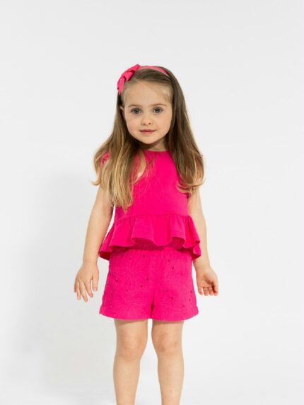 Completo due pezzi La Vie En Rose Completo due pezzi composto da: T.shirt senza maniche con scollo tondo, volant in sangallo al giromanica e fondo a balza, chiusura con bottone a goccia sul retro + Shorts in tessuto sangallo con elastico in vita dietro.