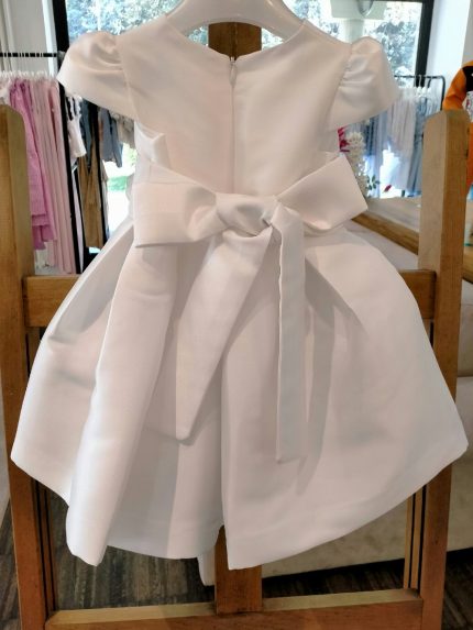 Abito Anemone Mimilù Abito neonata con manichine corte per Battesimo e cerimonia, confezionato in elegante tessuto mikado in tinta unita bianco e impreziosito dalla cintura regolabile in vita in raso con applicazione fiorata removibile, l'allacciatura posteriore ha la cerniera nascosta e grosso fiocco, la sottogonna è in cotone/tulle per rendere l'abito più ampio. Abito da Battesimo Abito da Cerimonia Neonata