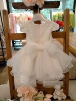 Abito Calla Mimilù Abito da cerimonia e Battesimo color latte, modello con manichine in misto cotone con gonna in tulle multistrato e ampia sottogonna, elegante corpino in pizzo debrodè, chiusura con zip invisibile sul retro. Nastro color latte in vita con applicazione floreale removibile e maxi fiocco sul retro. Abito da Battesimo Glam Abito da Cerimonia Neonata
