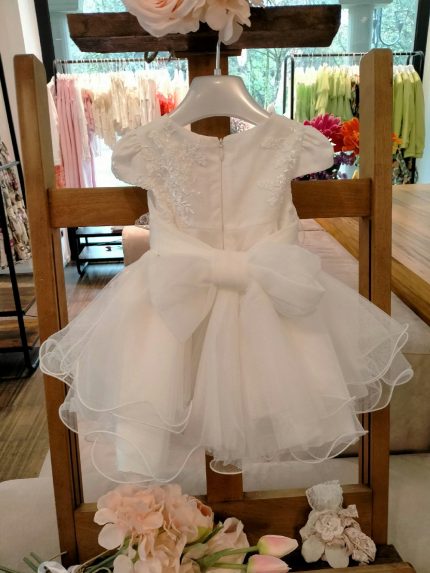 Abito Calla Mimilù Abito da cerimonia e Battesimo color latte, modello con manichine in misto cotone con gonna in tulle multistrato e ampia sottogonna, elegante corpino in pizzo debrodè, chiusura con zip invisibile sul retro. Nastro color latte in vita con applicazione floreale removibile e maxi fiocco sul retro. Abito da Battesimo Glam Abito da Cerimonia Neonata