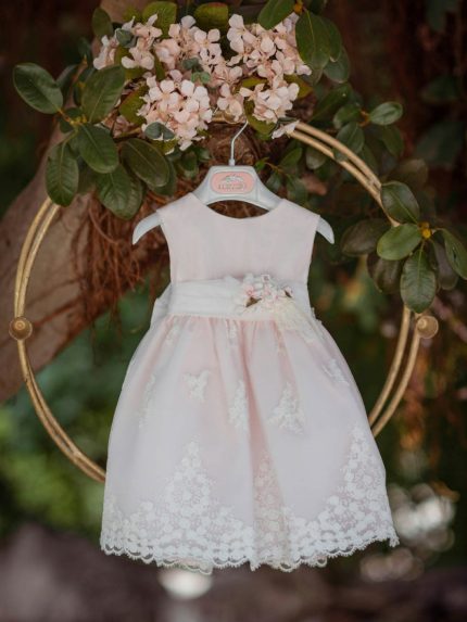 Abito Lillà Mimilù Elegante abito da cerimonia e Battesimo color rosa chiaro, modello senza maniche, corpino in tessuto di cotone doppiato in tulle color latte, ampia gonna in elegante pizzo debrodè con doppia sottogonna in tulle/cotone color rosa chiaro, chiusura con zip invisibile sul retro. Nastro color latte in vita con applicazione floreale removibile nei toni del rosa e glicine, allacciatura con maxi fiocco sul retro. Abito da Battesimo Glam Abito da Cerimonia Neonata