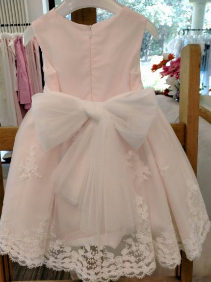 Abito Lillà Mimilù Elegante abito da cerimonia e Battesimo color rosa chiaro, modello senza maniche, corpino in tessuto di cotone doppiato in tulle color latte, ampia gonna in elegante pizzo debrodè con doppia sottogonna in tulle/cotone color rosa chiaro, chiusura con zip invisibile sul retro. Nastro color latte in vita con applicazione floreale removibile nei toni del rosa e glicine, allacciatura con maxi fiocco sul retro. Abito da Battesimo Glam Abito da Cerimonia Neonata