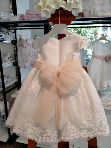 Abito Petunia Mimilù Abito da cerimonia e Battesimo color latte, modello con manichine corte, corpino in mikado, ampia gonna in elegante pizzo debrodè con doppia sottogonna in tulle/cotone, chiusura con zip invisibile sul retro. Nastro color rosa pesca in vita con applicazione floreale removibile e maxi fiocco annodabile con lembi sul retro. Abito da Battesimo Glam Abito da Cerimonia Neonata