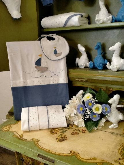 Asciugamano spugna Vela Quadrato spugna – 100% cotone – con cappuccio in tessuto fantasia Vela, profili in tessuto tinta unita color jeans. Made in Italy. Lista Nascita Corredino