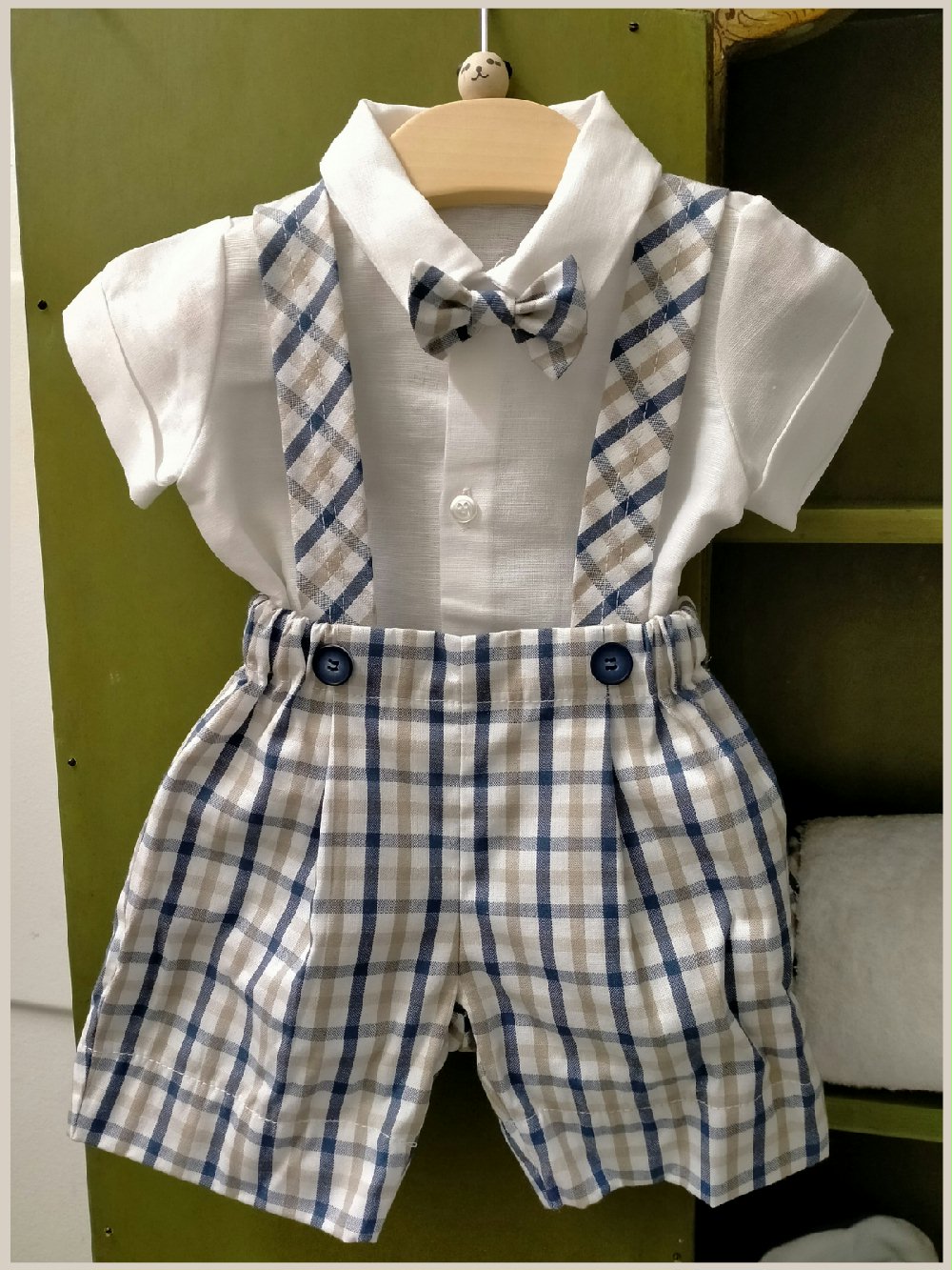Completo due pezzi Orsetto CB4900 Glam Lista Nascita Corredino 00 Completo due pezzi Orsetto Completo due pezzi per neonato misto lino/cotone composto da: pantaloncino corto con bretelle in fantasia check - 100% cotone - e body camicia a manica corta a tinta unita misto lino/cotone, abbinato papillon. Glam Lista Nascita Corredino