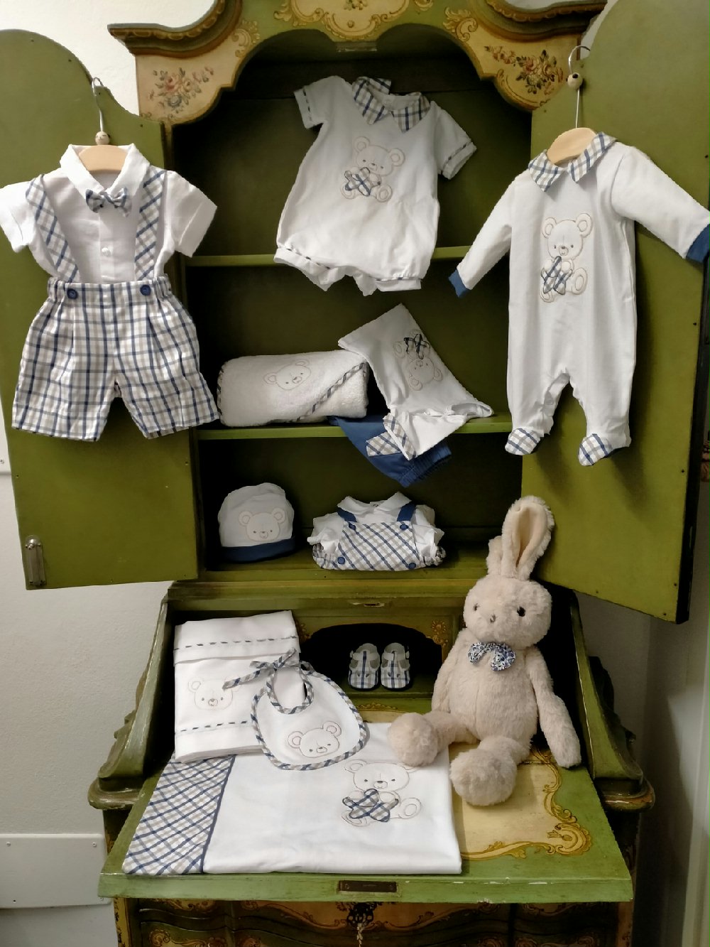 Completo due pezzi Orsetto Completo due pezzi per neonato misto lino/cotone composto da: pantaloncino corto con bretelle in fantasia check - 100% cotone - e body camicia a manica corta a tinta unita misto lino/cotone, abbinato papillon. Glam Lista Nascita Corredino