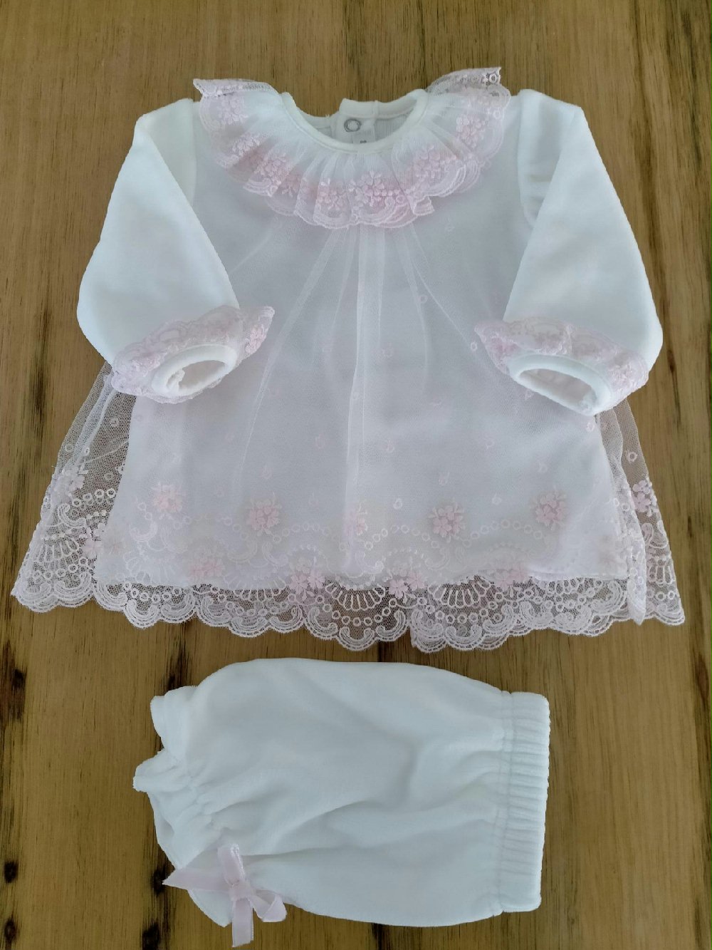 Completo due pezzi Roselline CC2420 00 Completo due pezzi Roselline Completo clinico corto in ciniglia per neonata, composta da: maglia con sopraveste in pizzo ricamato rosa e colletto tondo in tulle ricamato + mutandine in ciniglia. Made in Italy
